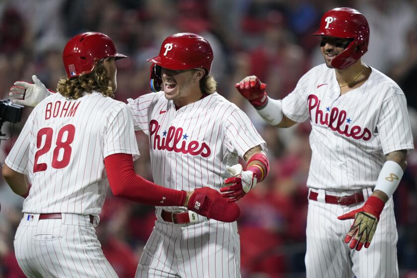 Philadelphia Phillies' Bryson Stott, center, celebrates with Alec Bohm, left, and Nick Castellanos after hitting a grand slam during the sixth inning of Game 2 in an NL wild-card baseball playoff series against the Miami Marlins, Wednesday, Oct. 4, 2023, in Philadelphia. (AP Photo/Matt Slocum)