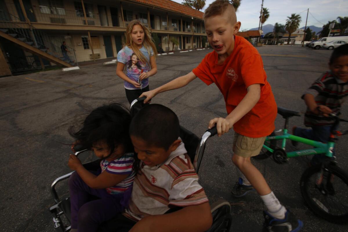 Los niños juegan en el estacionamiento del Country Inn en San Bernardino.