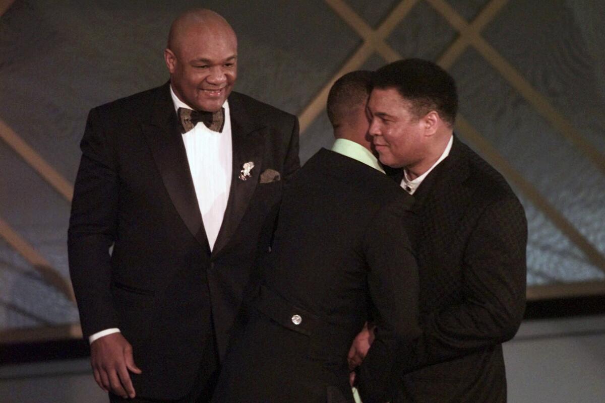 George Foreman looks on as Will Smith gives Muhammad Ali a hug during the Oscars in 2007. 