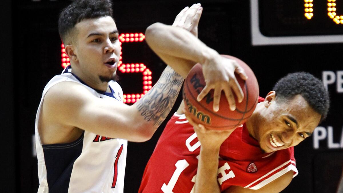 Utah guard Brandon Taylor (11) and Arizona guard Gabe York (1) fight for the ball during the second half Saturday.