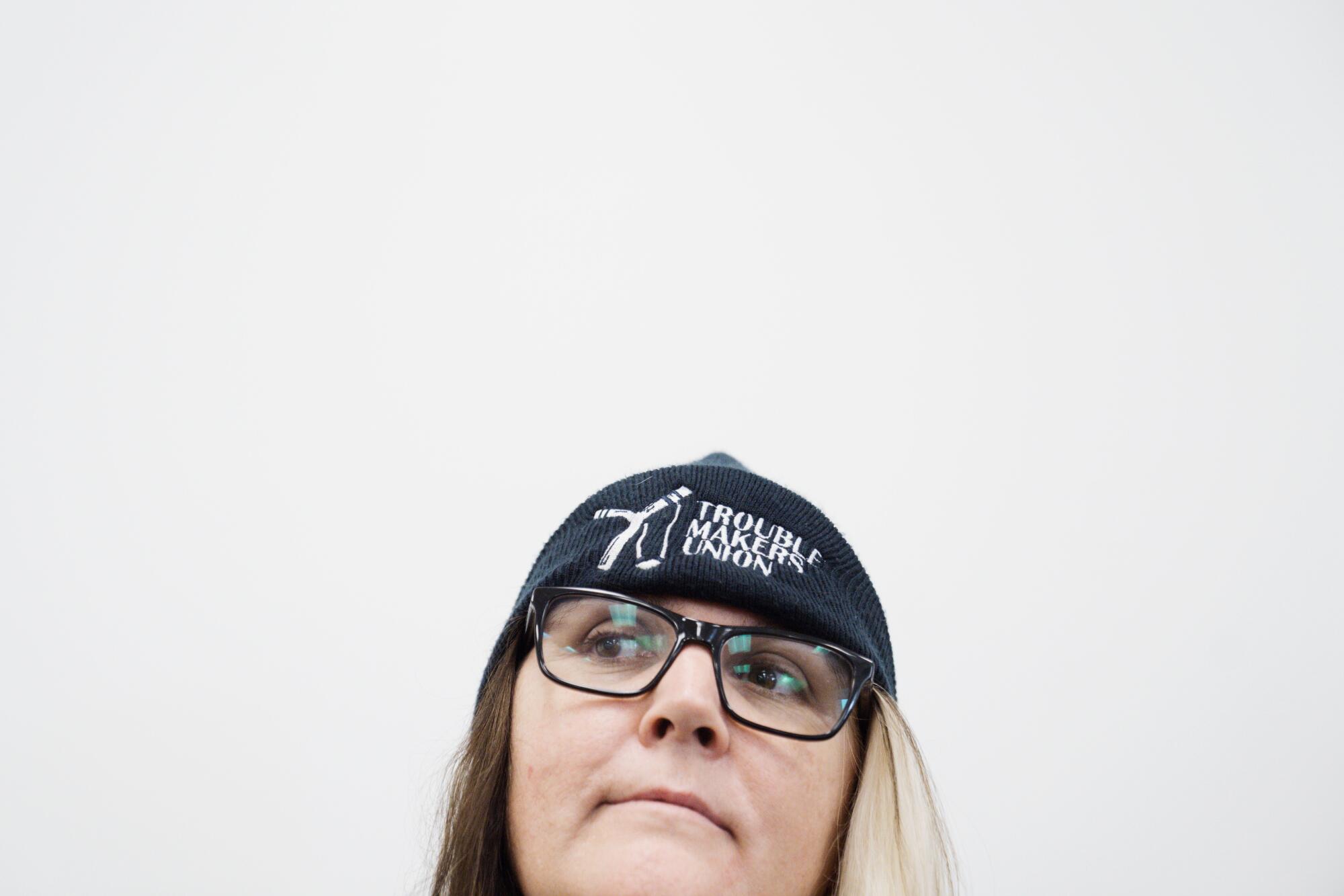 A woman is wearing glasses and a cap.