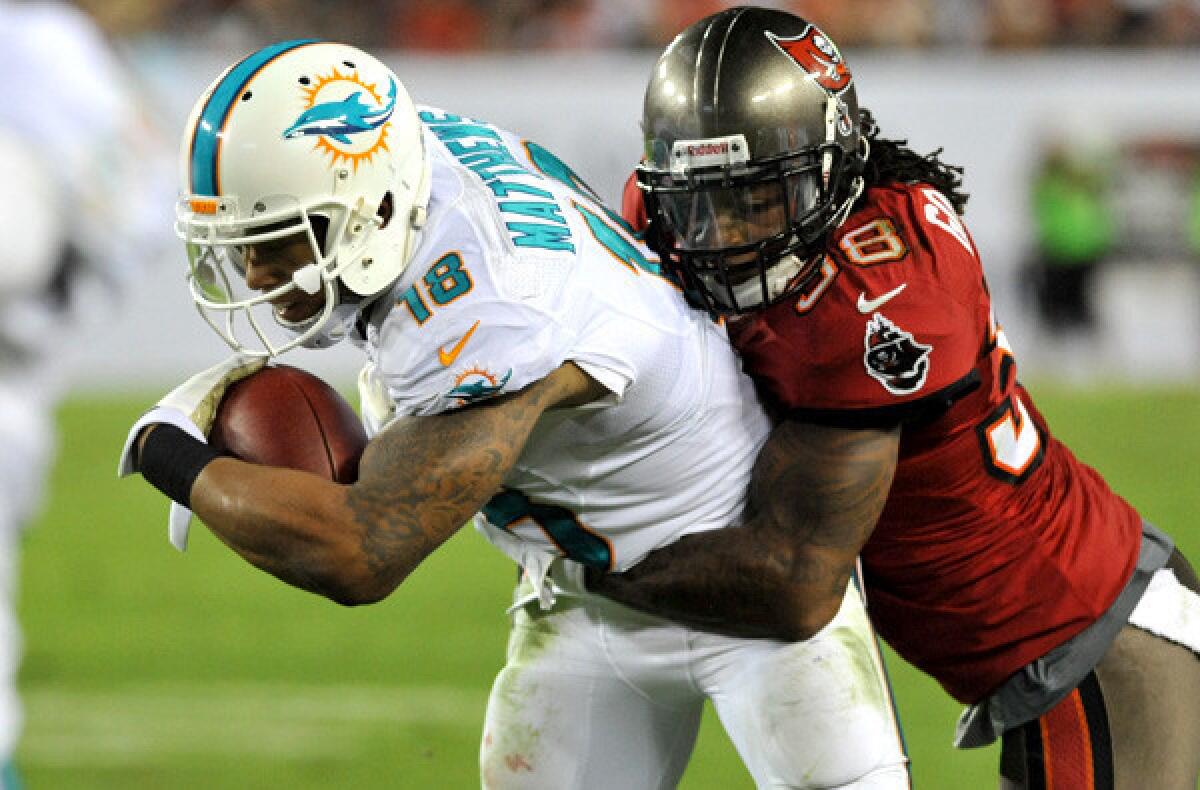 Buccaneers safety Dashon Goldson tackles Dolphins receiver Rishard Matthews during a game last month in Tampa, Fla.