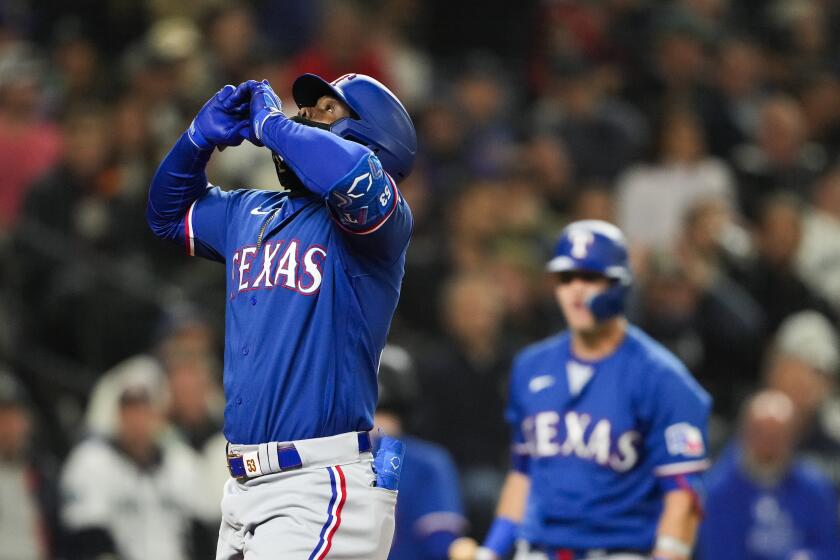 Texas Rangers' Adolis García reacts as he crosses home plate after hitting a solo home run against the Seattle Mariners during the fourth inning of a baseball game Thursday, Sept. 28, 2023, in Seattle. (AP Photo/Lindsey Wasson)