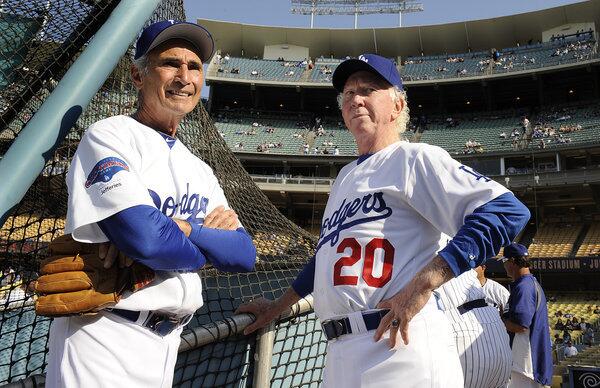 Former Dodger pitchers Sandy Koufax, left, and Don Sutton chat before an old-timers game at Dodger Stadium Saturday.