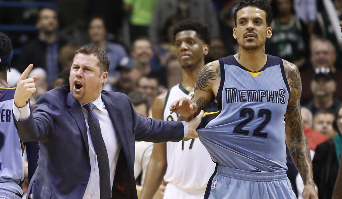 Grizzlies Coach David Joerger holds back Matt Barnes (22) after a double technical was called on Barnes and Milwaukee's John Henson late in a game Thursday.