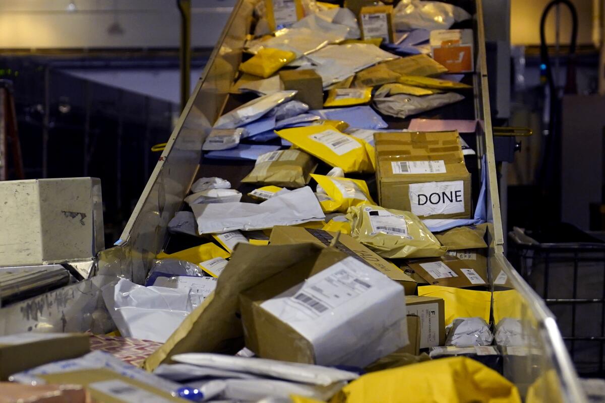 Paquetes en una cinta de distribución en una instalación de clasificación y procesamiento del Servicio Postal 