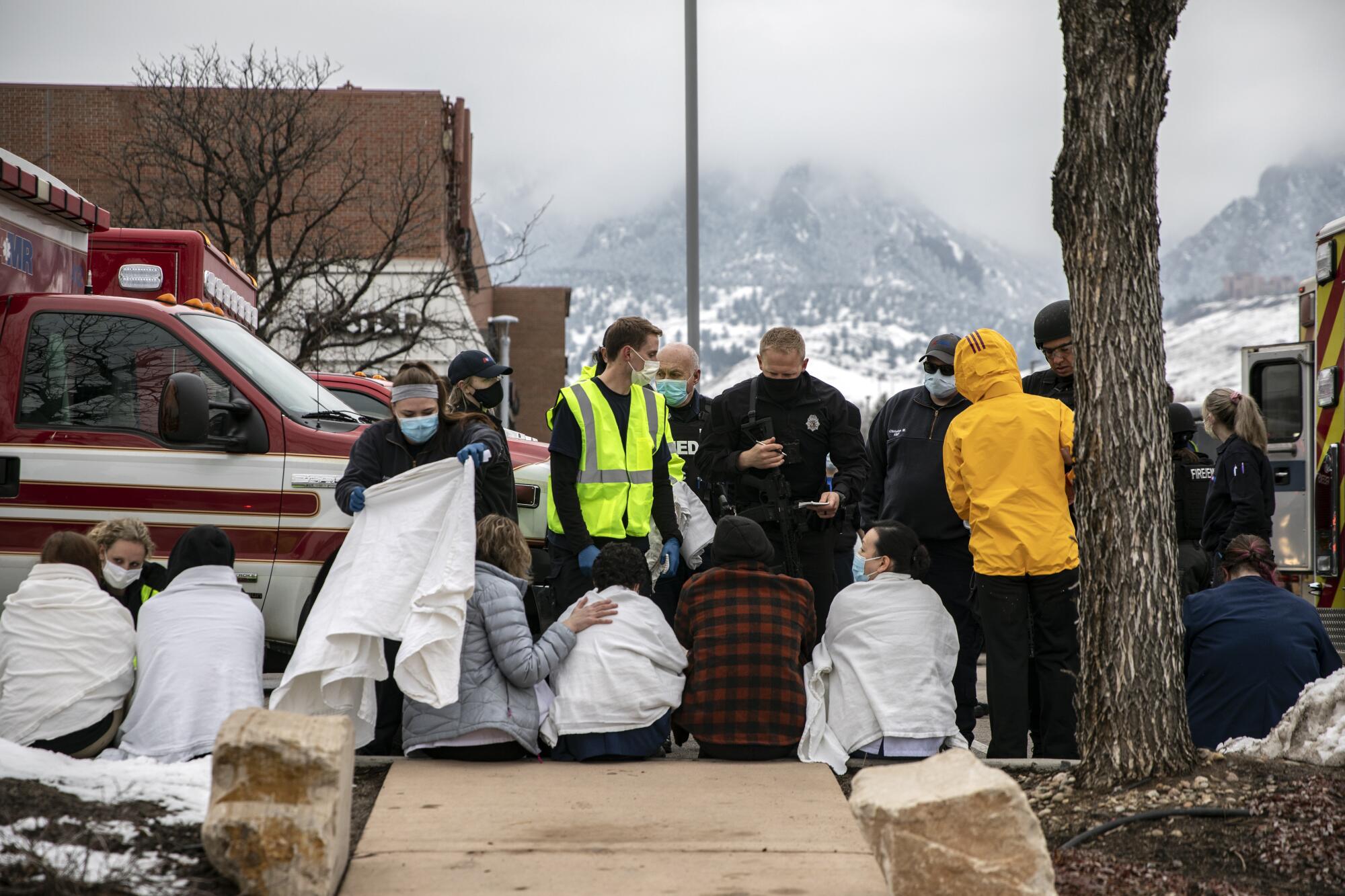 Healthcare workers and shoppers are tended to after being evacuated from a King Soopers grocery store 