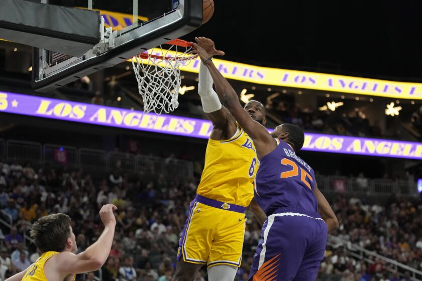 Los Angeles Lakers forward LeBron James (6) blocks a shot by Phoenix Suns forward Mikal Bridges (25) during the first half of a preseason NBA basketball game Wednesday, Oct. 5, 2022, in Las Vegas. (AP Photo/John Locher)