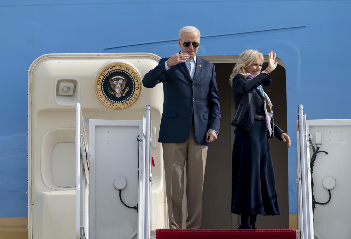 Joe Biden y su esposa Jill saludan desde la escalinata del avión presidencial 