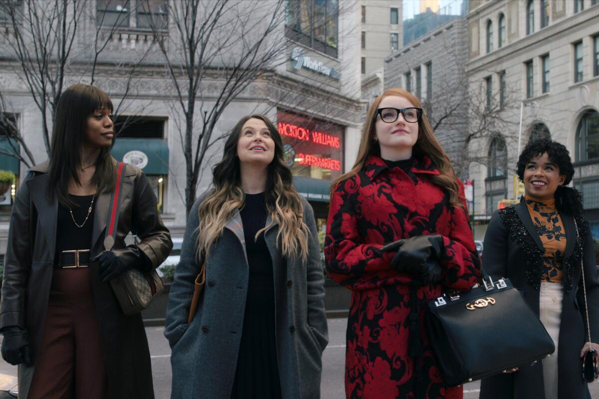 Four women walk abreast in a city in winter