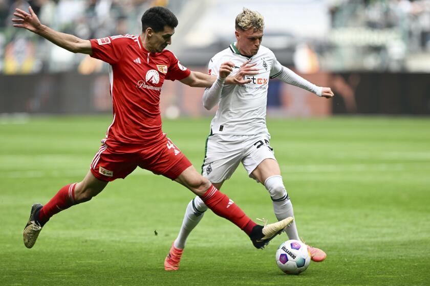 Moenchengladbach's Robin Hack, right, and Berlin's Diogo Leitet, left, challenge for the ball during German Bundesliga soccer match between Borussia Moenchengladbach and 1. FC Union Berlin in Moenchengladbach, Germany, Sunday, April 28, 2024. (Federico Gambarini/dpa via AP)
