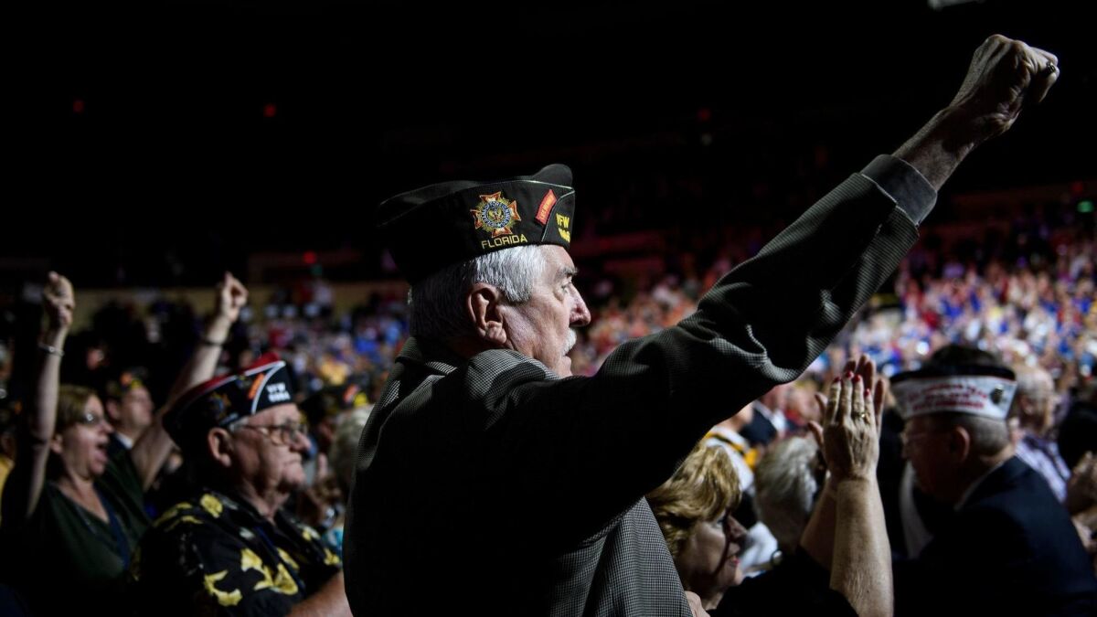 People cheer as President Trump speaks at the annual convention of the Veterans of Foreign Wars on Tuesday in Kansas City, Mo.