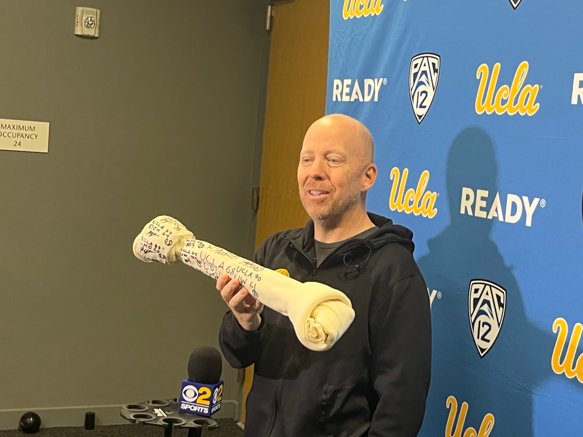 UCLA coach Mick Cronin holds the Bruins' Hungry Dog Award.