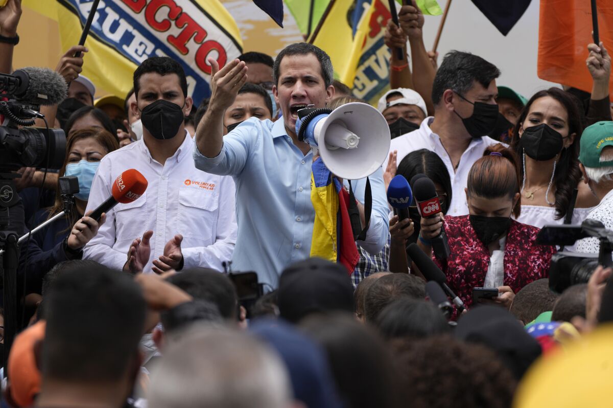 FILE - Opposition leader Juan Guaido, center, speaks to supporters during a gathering to mark Youth Day, in Caracas, Venezuela, Saturday, Feb. 12, 2022. Guaido was physically attacked Saturday, June 11 during a visit to a rural community, according to members of his parallel government, who accused a group of ruling party associates of carrying out the assault. (AP Photo/Ariana Cubillos, File)