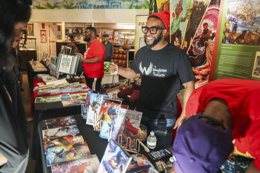 SAN DIEGO, CA-FEB 11 :Malachi Bailey shows off comic books the Wingless Comics booth at the San Diego Black Com!x Day 2023 at The WorldBeat Cultural Center in Balboa Park on Saturday, February 11 2023 in San Diego. The event featured Black artists and writers in the comic book industry including creators from Marvel Comics, DC Comics, Image Comics and a host of Black-owned independent publishers as well as featured Interactive Games and Activities for kids and panel discussions. (Sandy Huffaker for The San Diego Union Tribune)