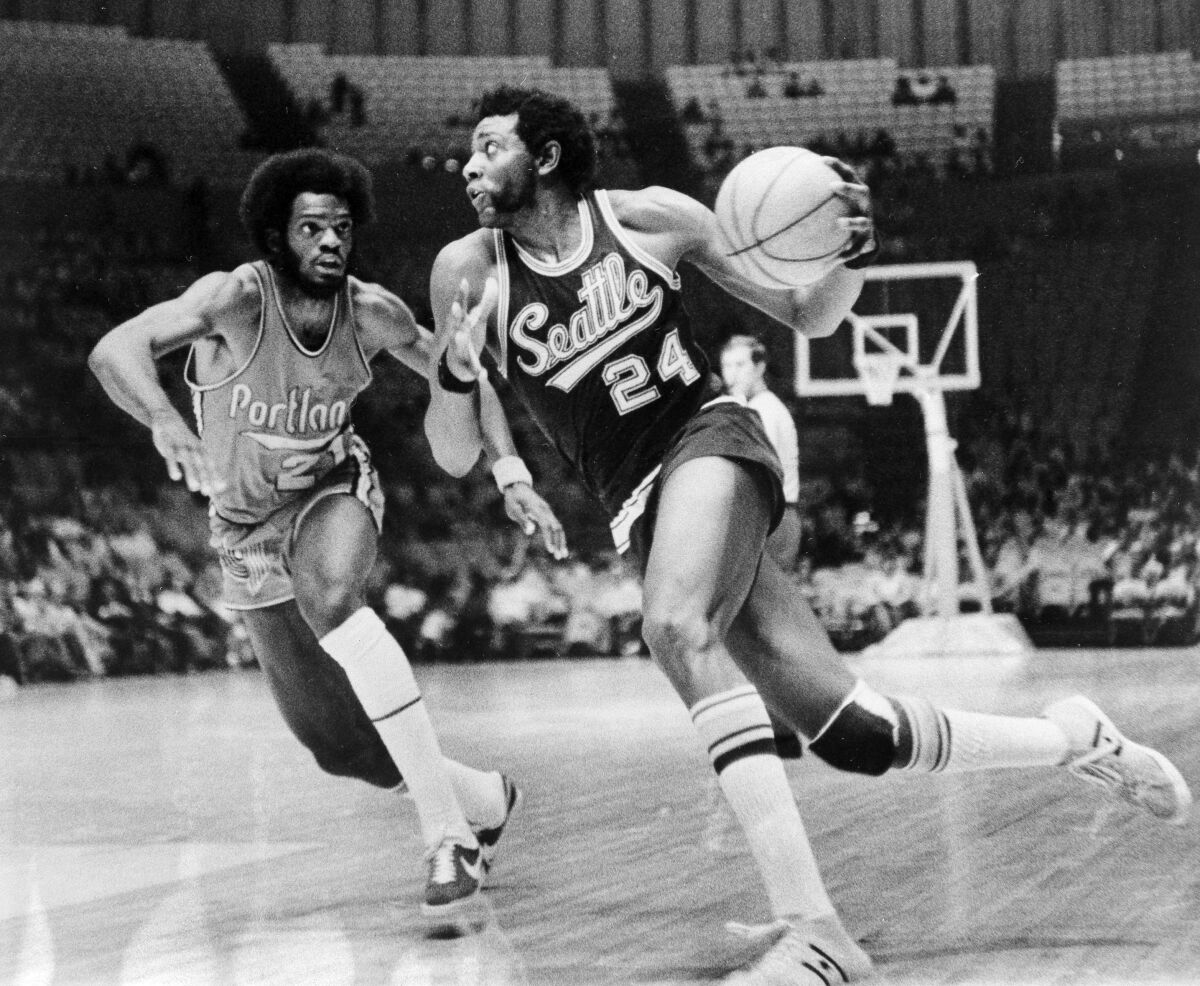 Seattle's Spencer Haywood dribbles around Portland's Sidney Wicks during a game on Oct. 7, 1972.