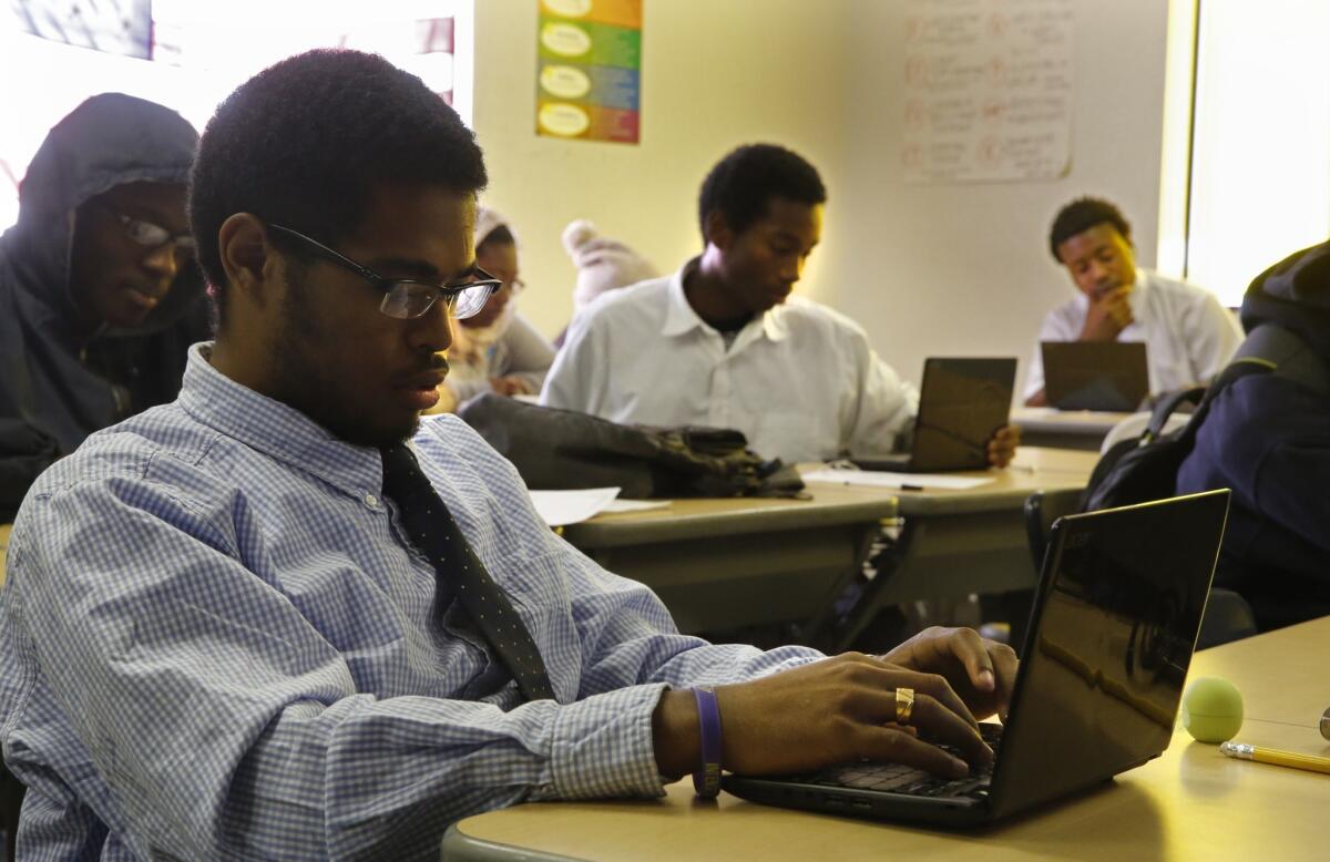 At Fredrick Douglass Academy High School, senior Devin Lodge and classmates use Internet connected notebooks for research in a Rhetoric & Composition class in May.