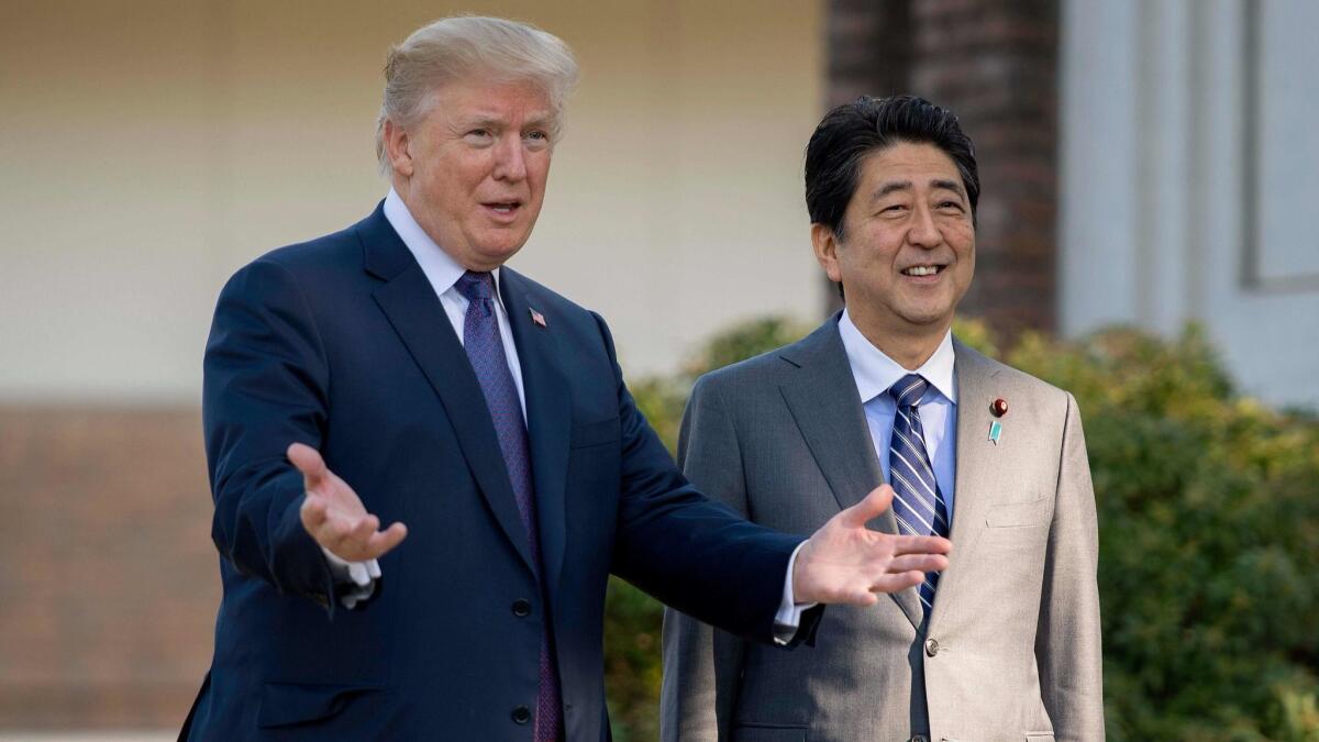 Donald Trump gestures as he speaks with Japanese Prime Minister Shinzo Abe on Nov. 5, 2017, outside Tokyo.