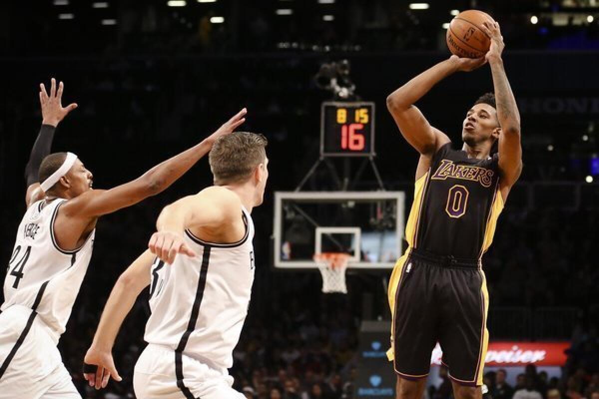 The Lakers' Nick Young shoots over Brooklyn's Mirza Teletovic and Paul Pierce, left, during the Lakers' 99-94 win Wednesday over the Nets at Barclays Center.