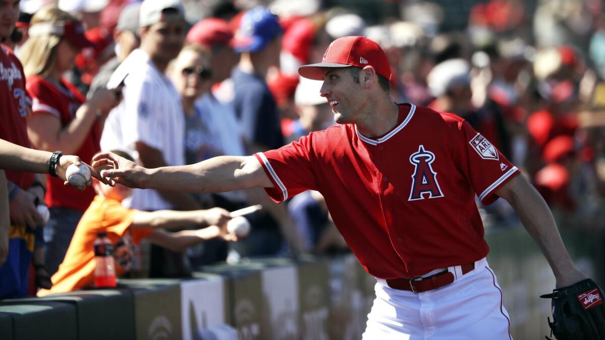 Angels outfielder Peter Bourjos reaches for a ball to sign before a spring training game against the Cubs on March 5 in Tempe, Ariz.