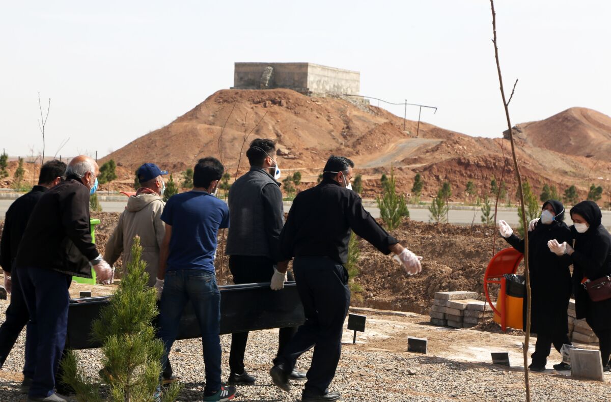 People carry the coffin of a victim of the novel coronavirus at Beheshte Masoumeh Cemetery in Qom, Iran, on March 17, 2020.