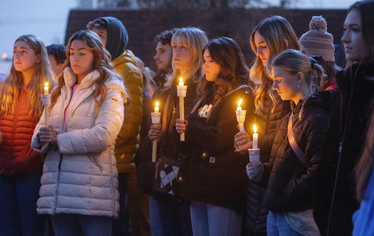People hold candles while attending a vigil. 