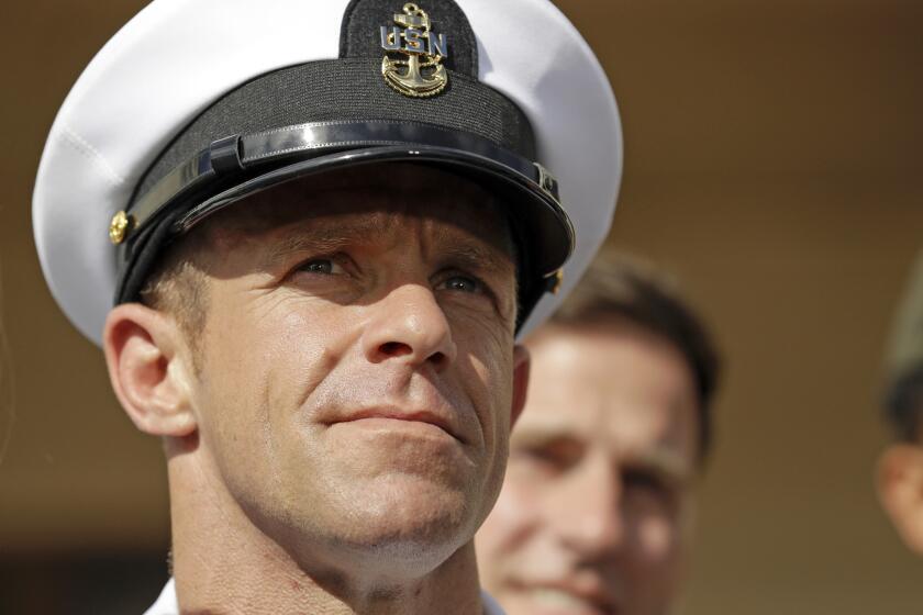 FILE - In this Tuesday, July 2, 2019, file photo, Navy Special Operations Chief Edward Gallagher leaves a military court on Naval Base San Diego. The attorney for Gallagher, convicted of posing with a dead captive in Iraq, says the Navy is trying to remove the special operations chief from the elite fighting force in retaliation for President Donald Trump restoring his rank. Defense attorney Timothy Parlatore said the Navy is holding a review board proceeding to remove Edward Gallagher's Trident pin and summoned him to meet with the SEAL leadership on Wednesday, Nov. 20, 2019. (AP Photo/Gregory Bull, File)