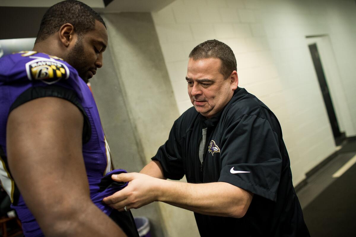 Bud Reinecke helps a Raven adjust his jersey.