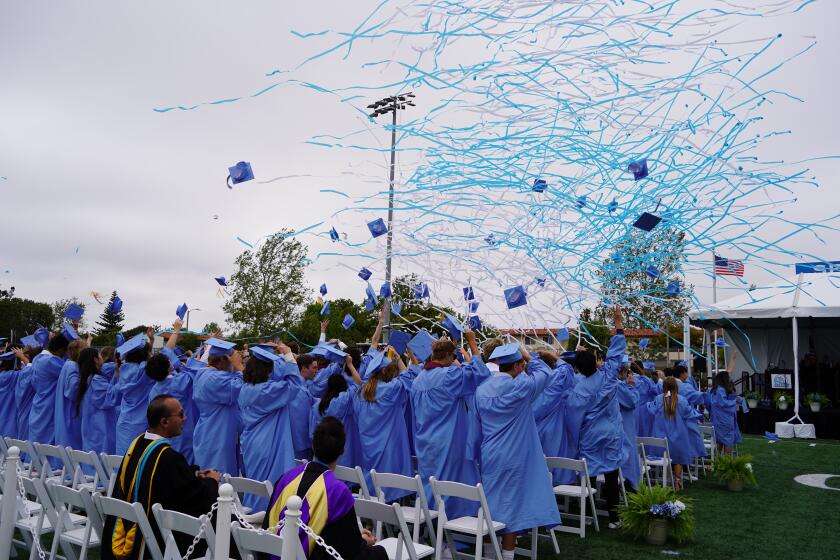 The graduating class of 2024 at Corona del Mar High School toss their caps into the air Thursday afternoon.