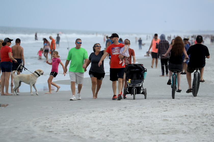 JACKSONVILLE BEACH, FLORIDA - APRIL 19: People walk down the beach on April 19, 2020 in Jacksonville Beach, Florida. Jacksonville Mayor Lenny Curry announced Thursday that Duval County's beaches would open from 7 a.m. until 11 a.m. and from 5 p.m. until 7p.m. after a decrease in coronavirus (COVID-19) cases. (Photo by Sam Greenwood/Getty Images)