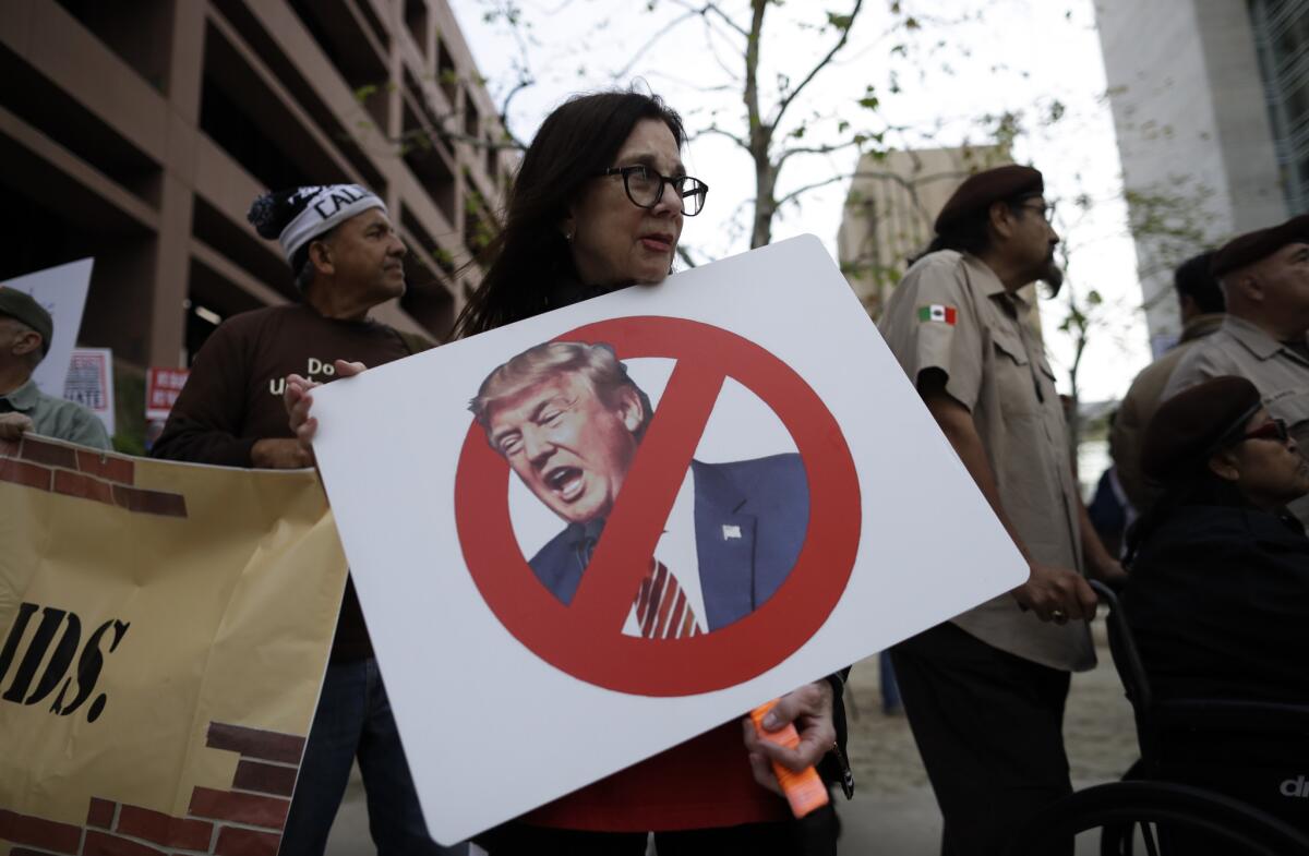 Jill Green sostiene un cartel durante una marcha contra el presidente Donald Trump, en San Diego, California, el 12 de marzo de 2018. Trump vista el estado el 13 de marzo.