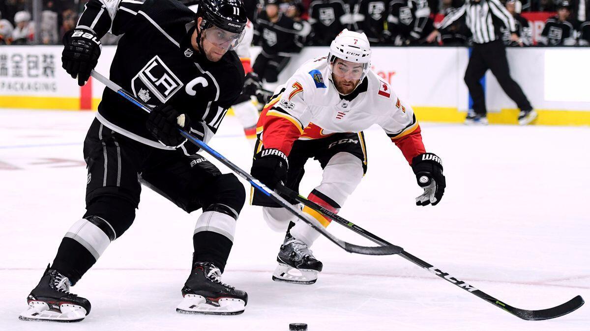 Kings' Anze Kopitar, left, makes a move past Calgary Flames' T.J. Brodie during the second period at Staples Center on Wednesday.