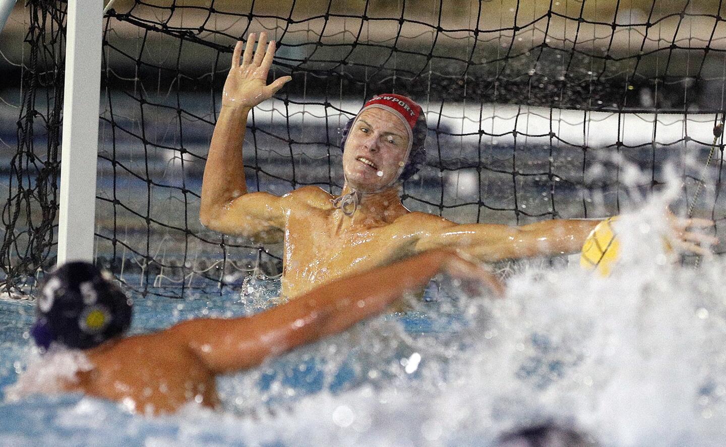 Newport Harbor High goalkeeper Blake Jackson makes a stop on a Corona del Mar shot in the fourth quarter of a Surf League boys' water polo match at Newport Harbor High on Wednesday, October 3, 2018.