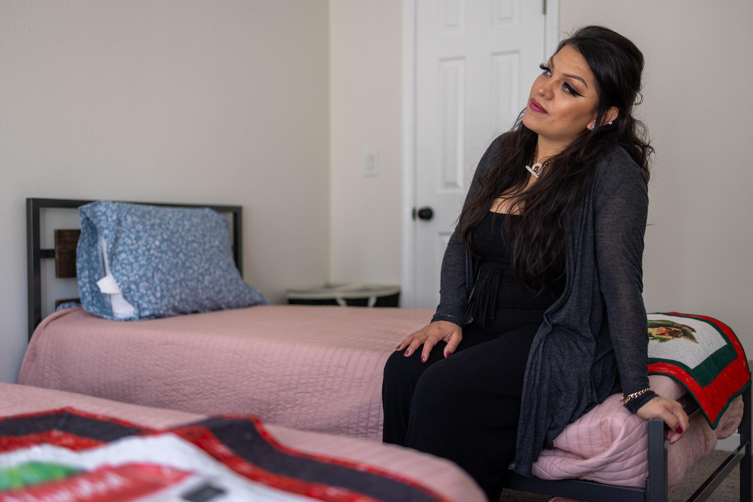 Kimberly, de 30 años, sentada en una cama en su nueva habitación 