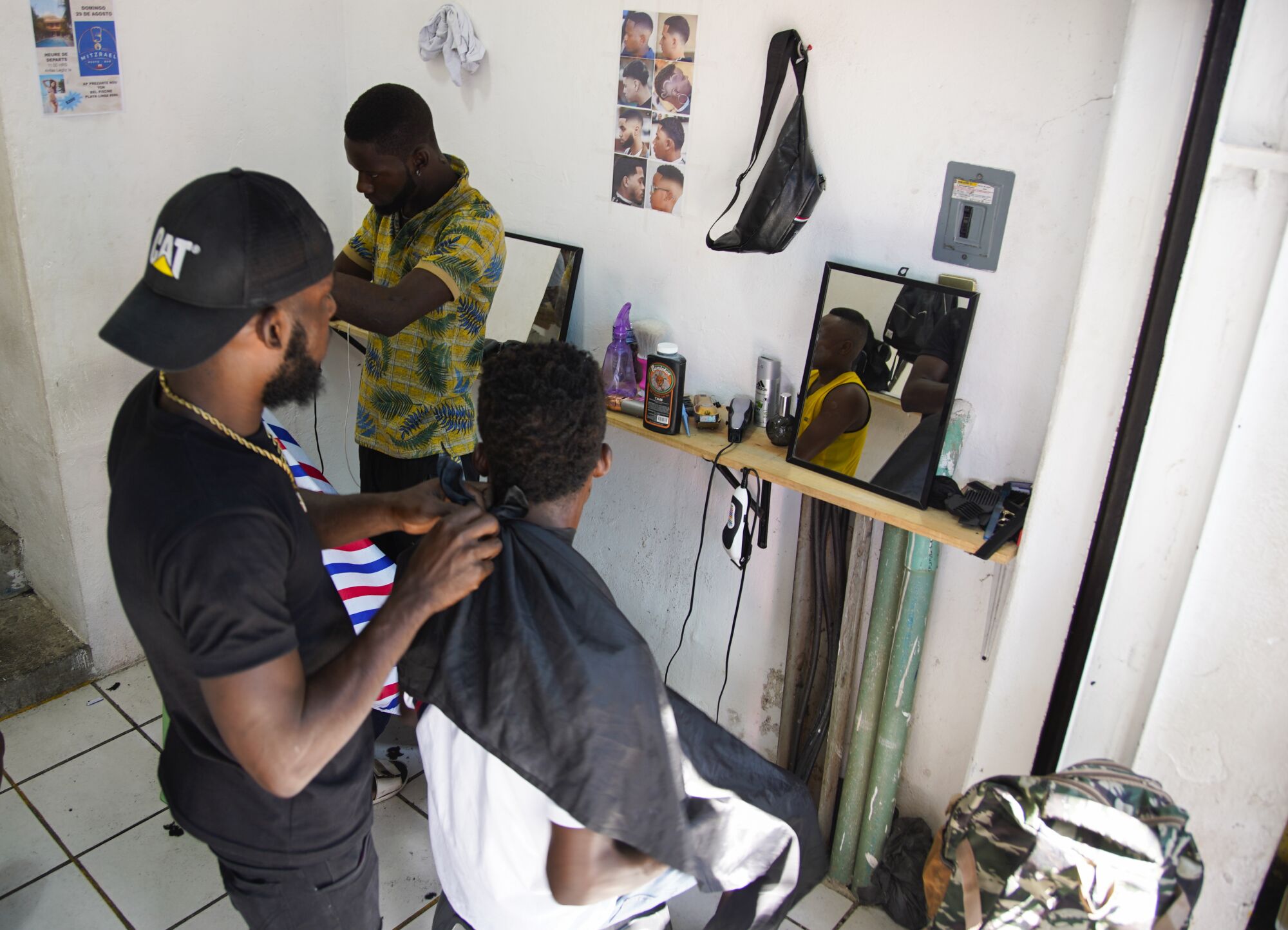 A Haitian man cuts hair in the barbershop he opened recently