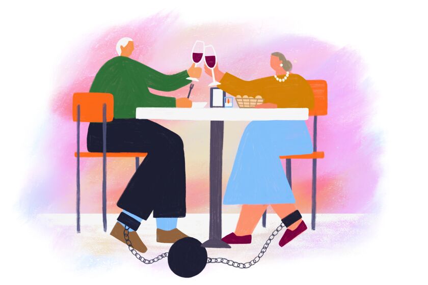 A couple raise their wine glasses in a toast, while below the table their ankles are chained to a weight.