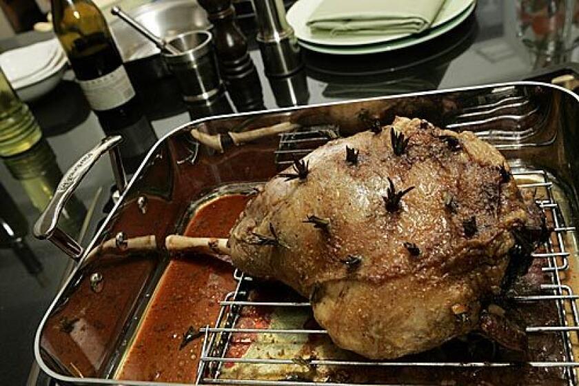 GOLDEN CRUST: Roast leg of lamb is studded with sprigs of rosemary, anchovy fillets and garlic. Click here for the recipe.