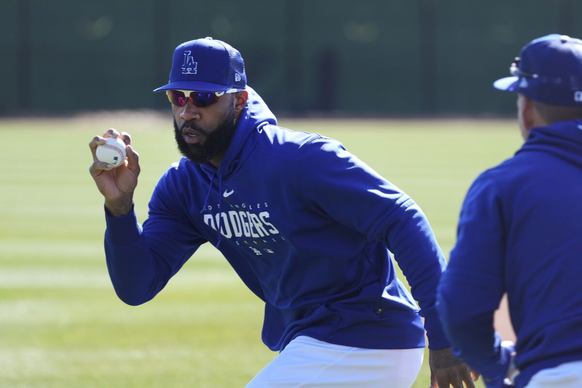 Dodgers outfielder Jason Heyward reaches for the ball during outfielder drills.
