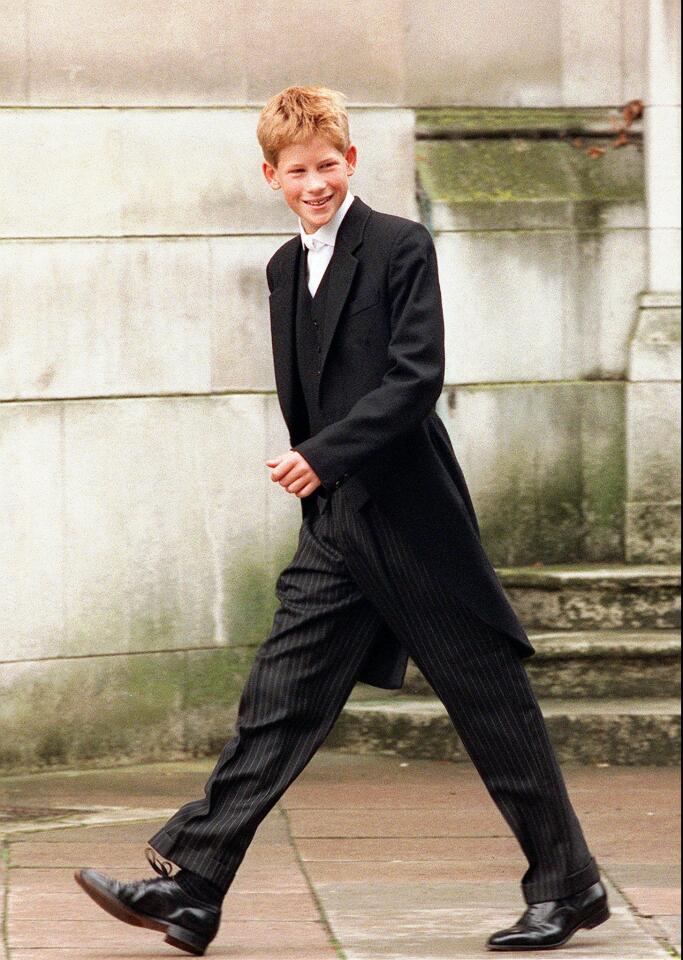 Britain's Prince Harry, 13, walks in his distinctive school uniform of black tailcoat, striped trousers, waistcoat and stiff white collar to begin his lessons on his first full day at Eton school, near Windsor, Thursday, Sept. 3, 1998.
