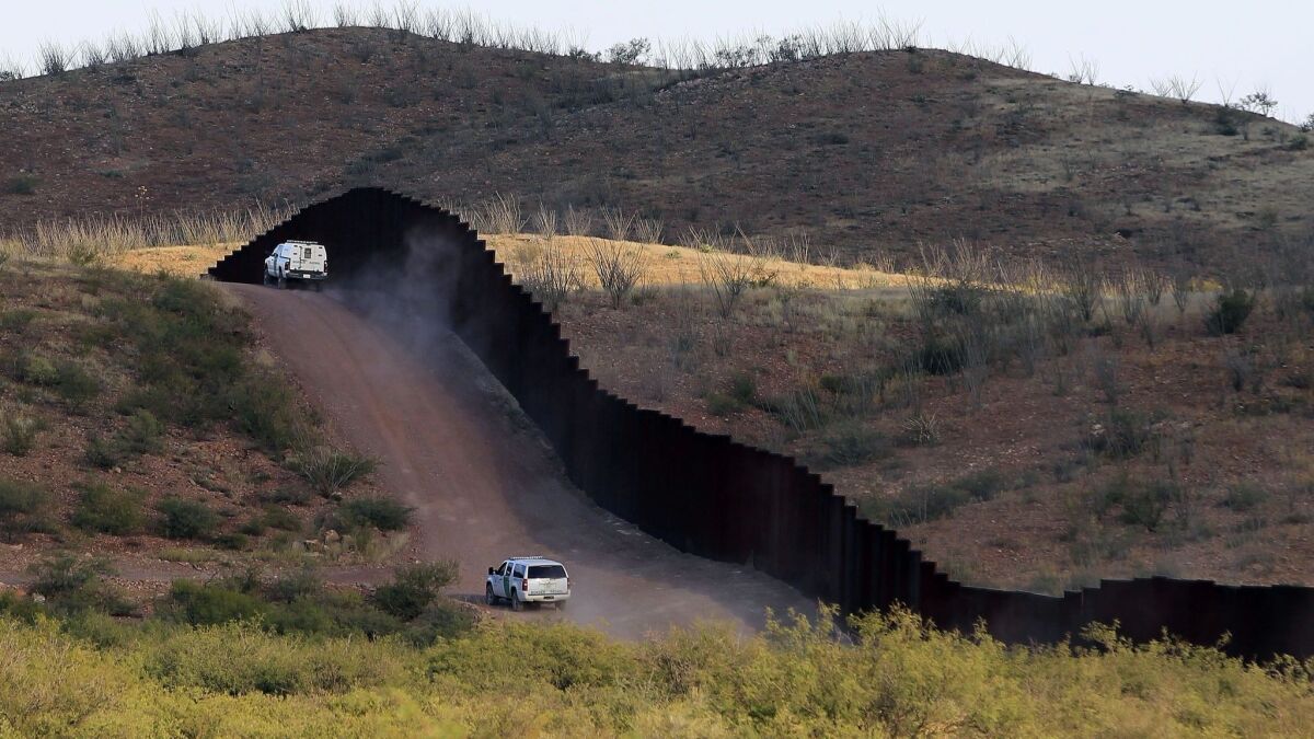U.S. Border Patrol agents work along a border fence in Naco, Ariz., in 2012.