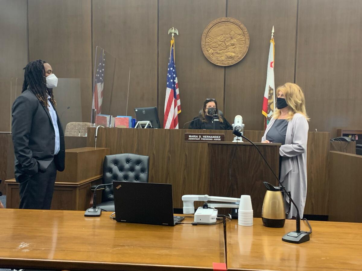 A judge and two people in a courtroom