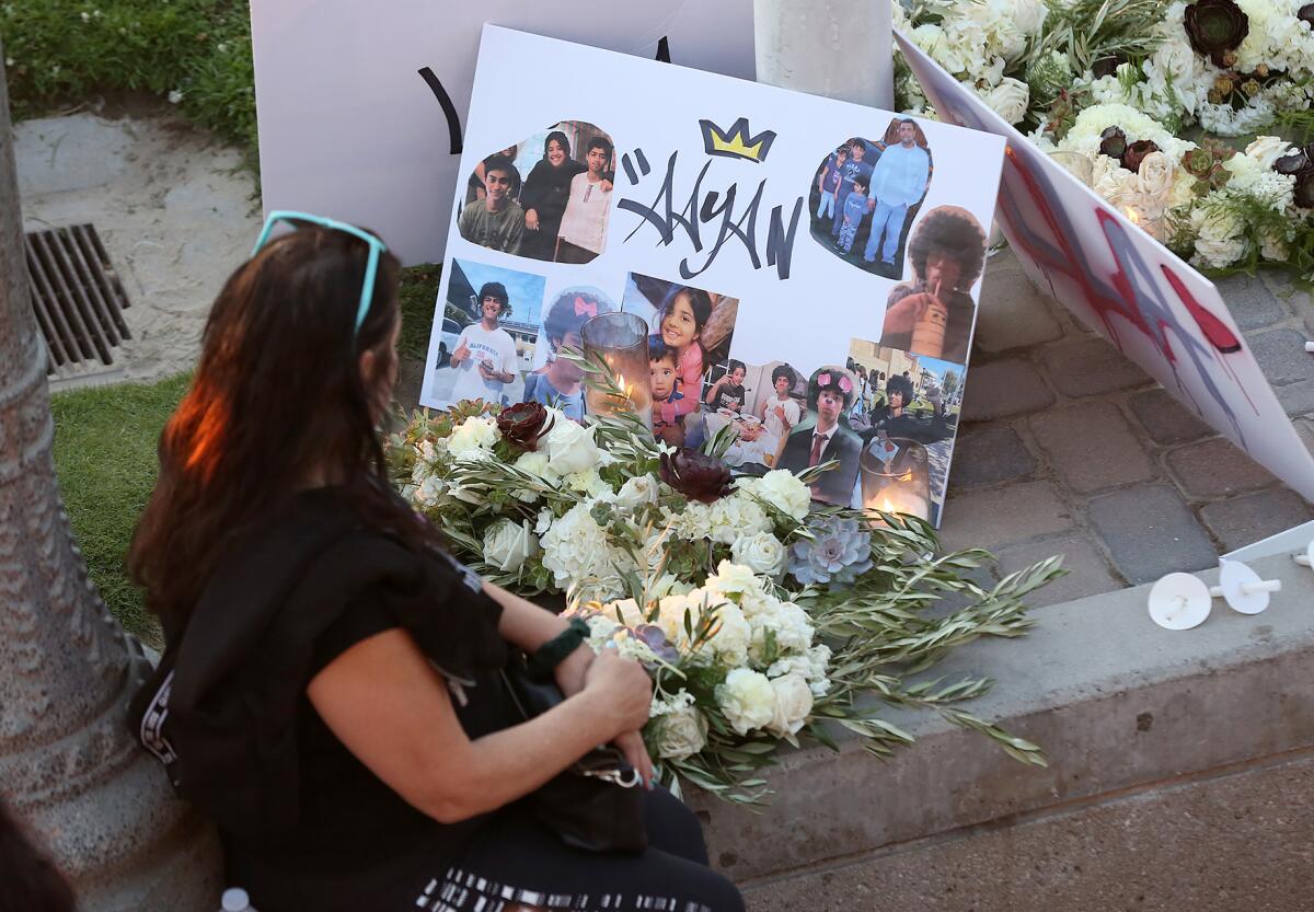 A woman prays next to a shrine for 15-year-old Aayan Randhawa. 