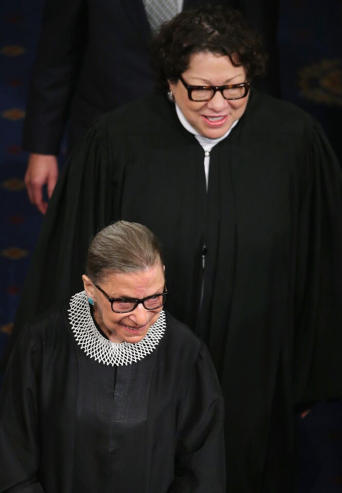 Ruth Bader Ginsburg and Sonia Sotomayor, wearing black robes, walk down the aisle of the House of Representatives
