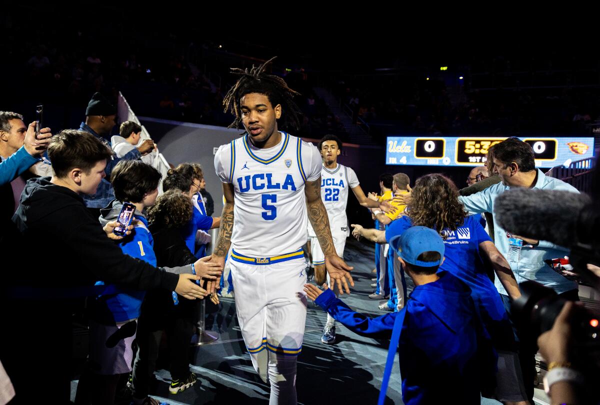 Fans reach out as UCLA guard Brandon Williams and forward Devin Williams enter the court before playing Oregon State