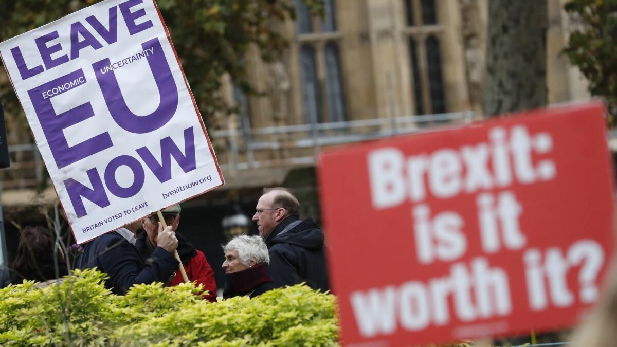 Pro- and anti-"Brexit" protesters hold placards Nov. 16 as they vie for media attention near Parliament in London.