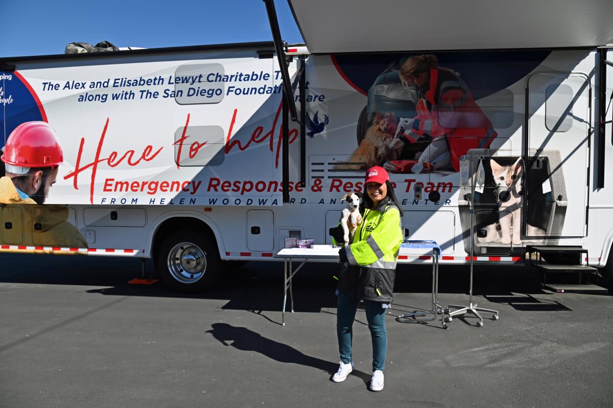 A Rescue Team member and furry buddy standing in front of the Helen Woodward Animal Center’s Emergency Response RV/Unit.