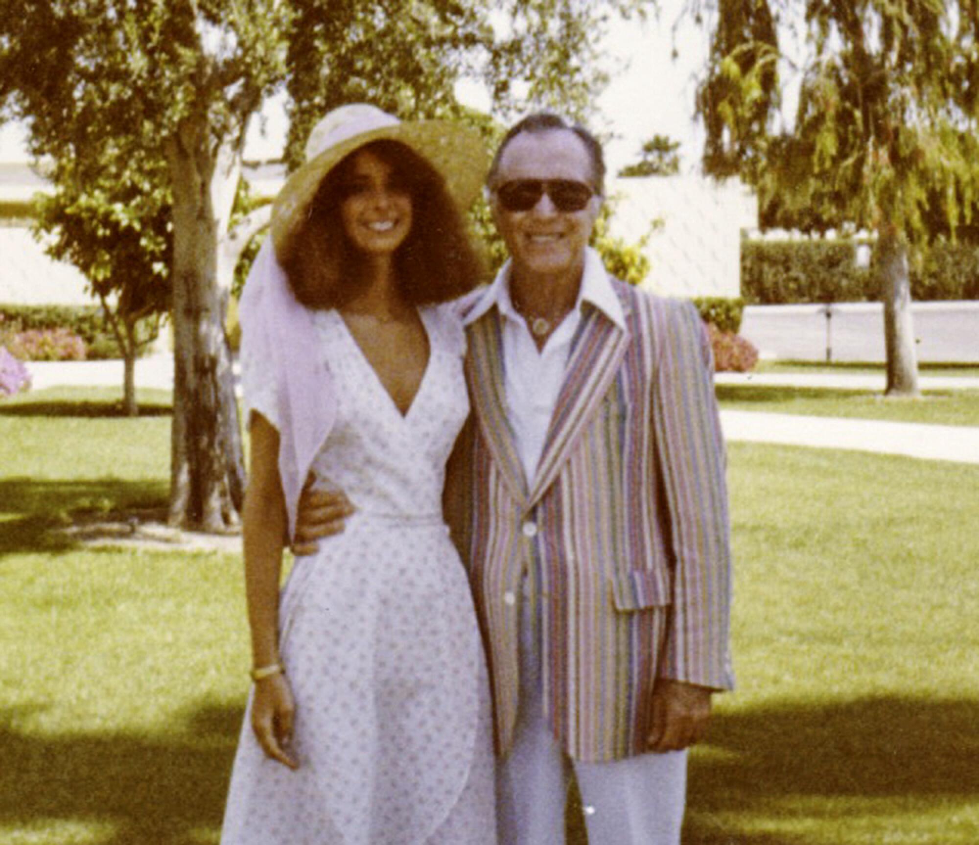 A photo of a man and a woman dressed up outdoors 