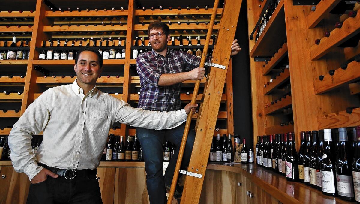 Brian McClintic, left, and Eric Railsbackpose at their wine shop Les Marchands in Santa Barbara.
