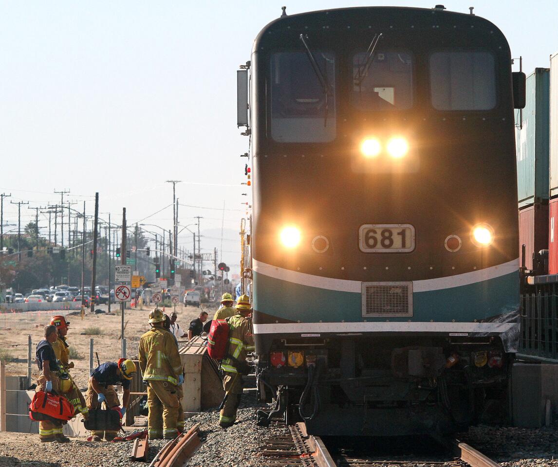 Burbank firefighters tend to the front car of a Metrolink train south of the intersection of San Fernando and Buena Vista in Burbank on Monday, September 2, 2014. The southbound train struck a motorist allegedly driving around the downed crossing arms on Buena Vista Street, totaling the vehicle and sending the driver to the hospital with critical injuries.