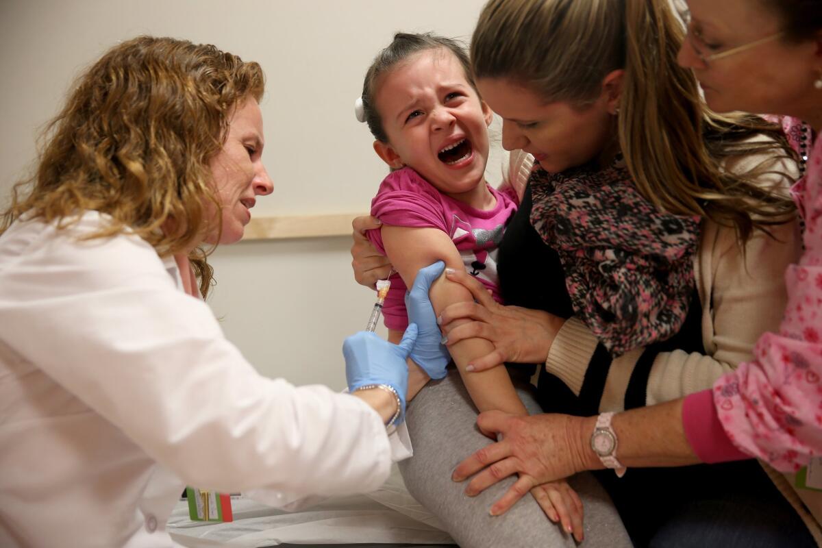 Miami Children's Hospital pediatrician Dr. Amanda Porro administers a measles vaccination to Sophie Barquin.